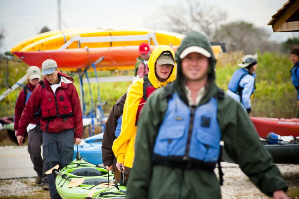 Volunteer with Kayaks heading out on a coastal restoration project